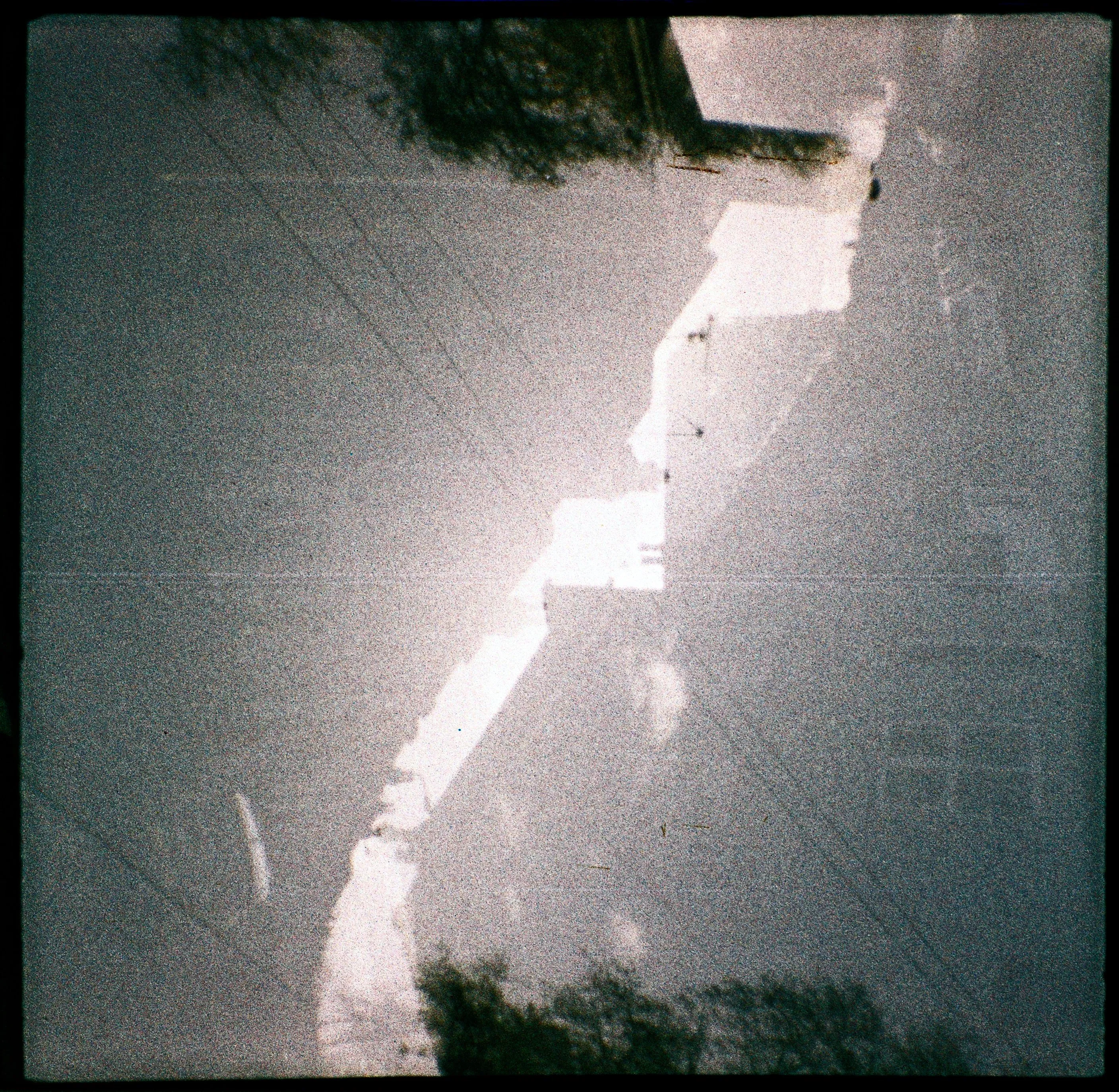 A double exposure of a line of houses, with each exposure inverted such that the rooftops fit neatly into each other. The photographer is particularly proud of this one but struggles to describe it well.