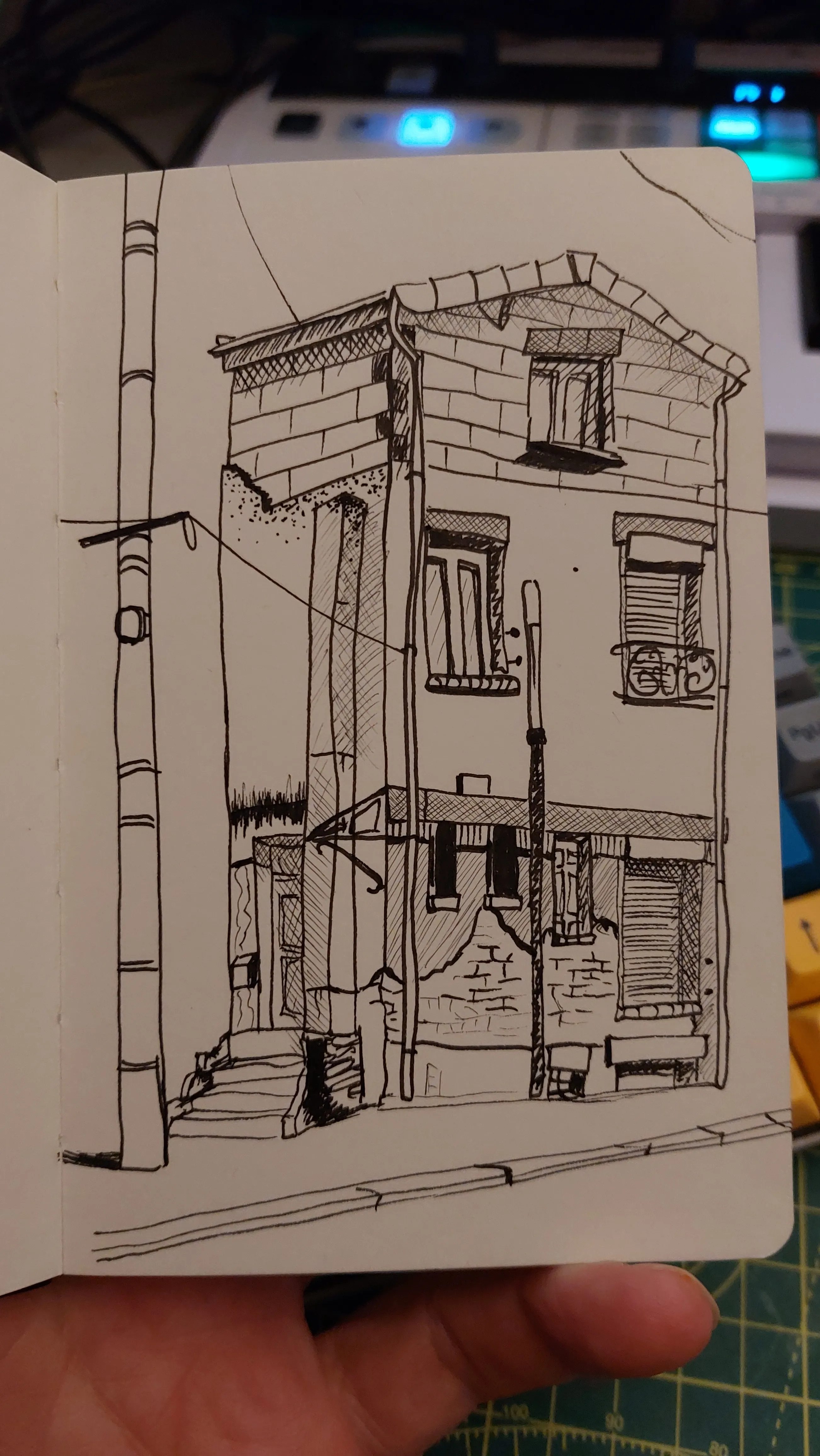 A line drawing of a French building. it has been built in an interesting way. Looks like each floor was added using different materials at a different time. Every door and window is different . It's hard to tell if the artist's perspective work is bad or if the building is wonky. Truth it it's actually both. This is another pen and ink drawing but this time with crosshatched shading.