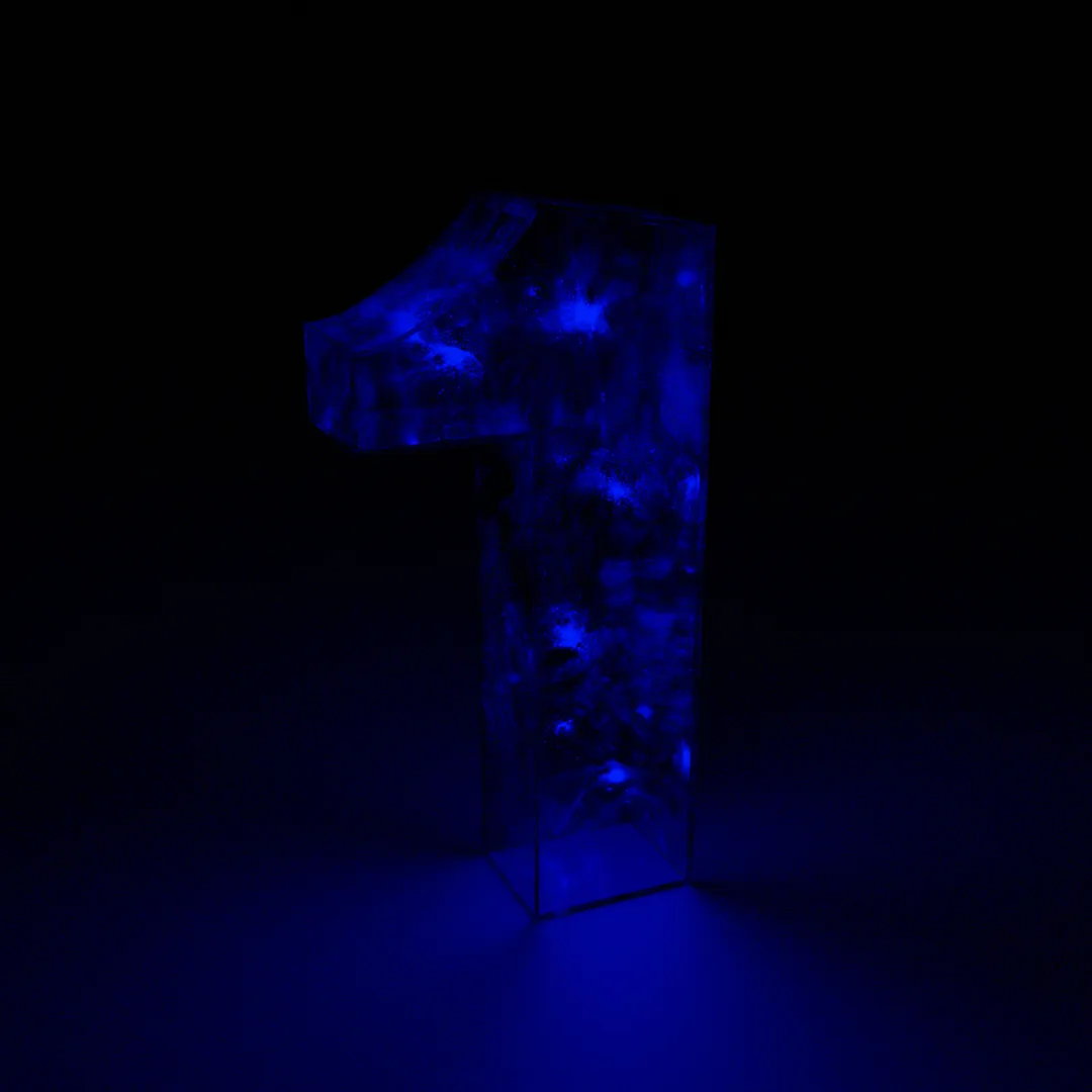 A 3D CGI render of the number 1. It is made of hollow glass and is illuminated only by small blue lights that float inside