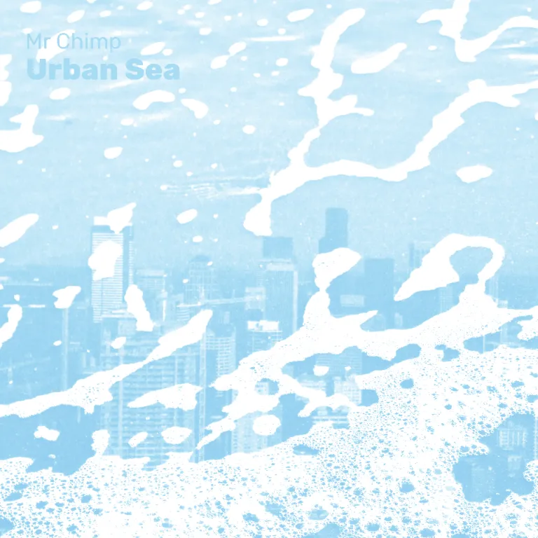An album cover. An image rendered in light blue and white monochrome. There is a cityscape in the background with the foam of waves on a beach layered over the top. The text reads "Mr Chimp. Urban Sea"